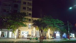 Thương Xà (2)Xuân Lan Hotel的夜间在城市街道上停车,停在大楼前