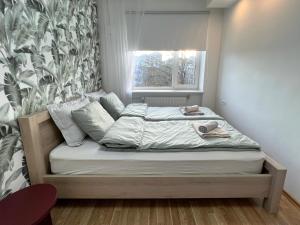 塔林Tallinn Panorama Apartment Majaka的窗户客房内的小床