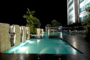乌汶苏内大酒店和会议中心的一座游泳池,晚上与大楼相连