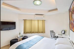 胡志明市ELIOT HOTELs的一间酒店客房,配有一张床和一台电视
