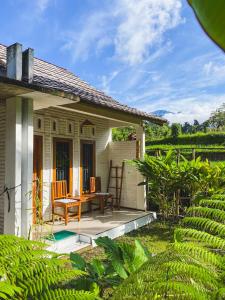 特特巴图Sarang Walet Homestay的房屋的庭院,配有桌椅