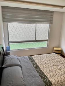 基多GOYA Suites y Comfort的一间卧室设有一张床和一个大窗户