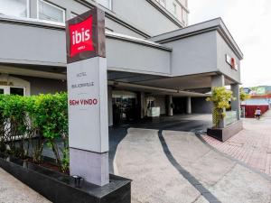 约恩维利ibis Joinville的前面有公共汽车标志的建筑