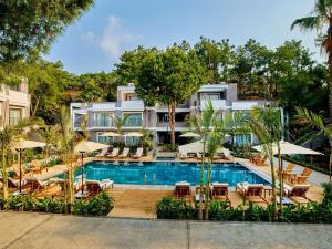 特基罗瓦Movenpick Resort Antalya Tekirova的酒店设有带椅子和遮阳伞的游泳池