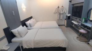首尔Shinchon Y Hotel的酒店客房设有两张床和电视。