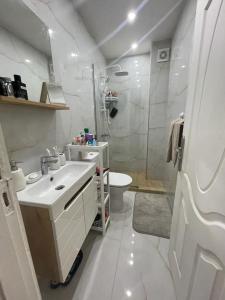 达赫拉Havre de Douceur Maison Cosy Confort et Style的白色的浴室设有水槽和卫生间。