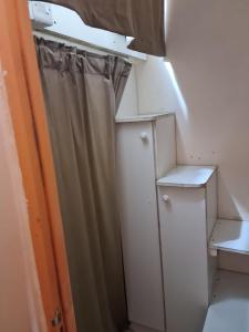 迪拜Al karama spacious hostel的小房间设有窗帘和衣柜