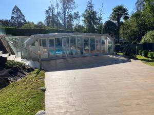 庞特维德拉Vigo Arlington Real Estate的一座玻璃房子,里面设有游泳池