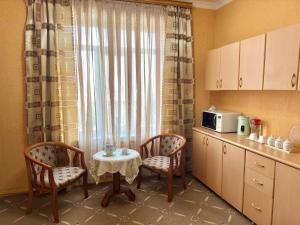 苦盏Bargi Sabz的厨房配有桌子和两把椅子,设有窗户。