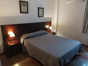 隆达Hostal San Cayetano的一间卧室配有一张床和两张台灯。