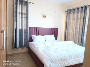 蒙巴萨Elegant furnished rooms with swimming pool in Nyali的一间卧室配有带白色床单和枕头的床。