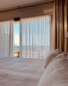 邦多勒普莱因大酒店的一间卧室设有一张床和一个大窗户
