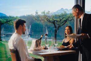 莱维科特尔梅杜拉克公园酒店的一群坐在桌子上的人,拿着食物和葡萄酒