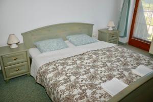 比克Éden Panzio的一间卧室配有一张带2个床头柜的大床