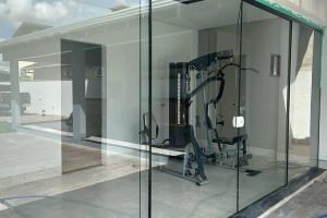 锡诺普Para dormir, curtir e trabalhar!的一间设有玻璃墙的健身房的客房