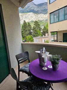 马卡尔斯卡Sweet suite的阳台配有紫色的桌椅