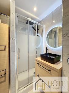 布赖迪讷Vue Capitainerie , Charme & Confort en Bord de Mer的一间带水槽和玻璃淋浴的浴室