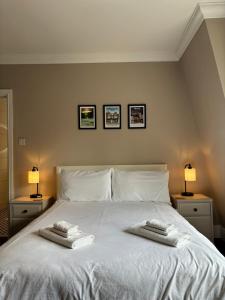 特灵Large West Side Room above G Grace & Son的卧室配有白色的床和2条毛巾