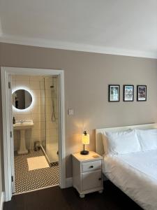 特灵Large West Side Room above G Grace & Son的一间卧室配有一张床,浴室设有淋浴。