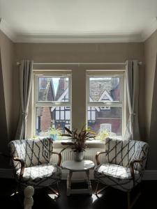 特灵Large East Side Room above G Grace & Son的窗前的两把椅子和一张桌子