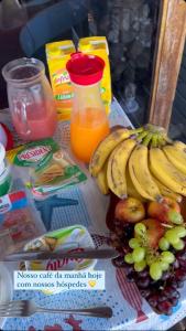 安格拉杜斯雷斯Mansão Espetacular Angra的一张桌子,上面放着一束香蕉和一些果汁