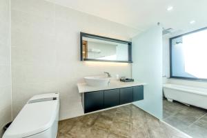 济州市艺术Spa＆普尔维拉酒店的浴室配有盥洗盆、镜子和浴缸