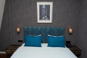 巴库Port Rivoli Baku Luxury Boutique Hotel的一间卧室配有一张带蓝色枕头的床