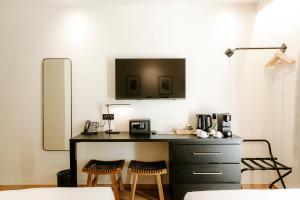雷穆兰Soko Hotels-Pont du Gard的厨房配有书桌和2把凳子