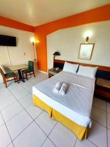 马瑙斯泰姬陵酒店 的酒店客房配有一张床铺、一张桌子和一张书桌。