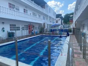 梅尔加Hotel san Jorge的坐在建筑物旁边的游泳池里的人