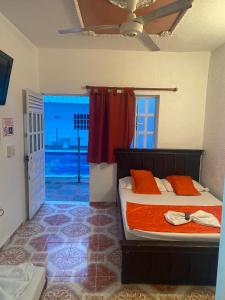 梅尔加Hotel san Jorge的一间卧室配有带橙色床单的床和窗户。