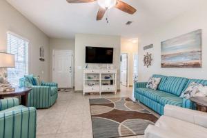 奥兰治比奇Orange Beach Villas - Casa Bella的客厅配有蓝色的沙发和平面电视。