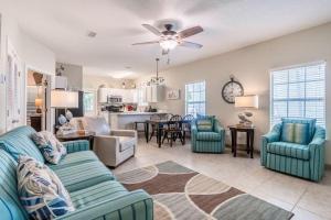 奥兰治比奇Orange Beach Villas - Casa Bella的一间带蓝色沙发的客厅和一间厨房