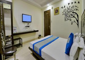 新德里Hotel University Stay @ A1Rooms的卧室配有一张床,墙上配有电视。