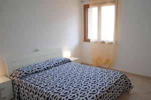 MaladrosciaNuovissimo appartamento a due passi dalla spiaggia di Maladroxia C61的一间卧室配有一张带蓝色棉被的床和窗户。