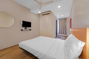 钦奈Hotel Stay inn Chennai Airport的卧室配有白色的床和平面电视。