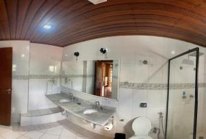 坎波斯杜若尔当Pousada Atalaia Capivari的浴室设有2个水槽、镜子和卫生间。
