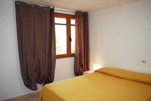 MaladrosciaAppartamento con veranda e aria condizionata a Maladroxia C62的一间卧室设有黄色的床和窗户。