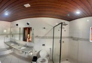 坎波斯杜若尔当Pousada Atalaia Capivari的一间带卫生间、水槽和镜子的浴室