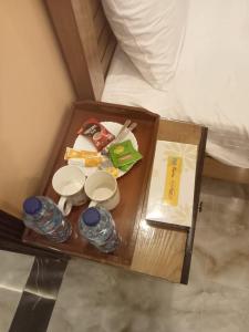 拉瓦尔品第Elite Living Hotels的床上的托盘,上面有食物和饮料