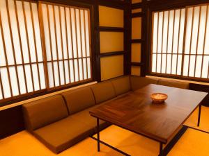 草津BUNA　KUSATSU的窗户客房内的一张带桌子的沙发