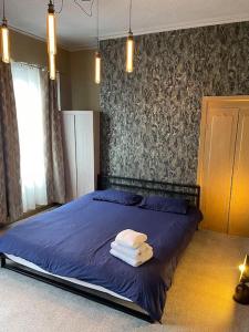 利物浦3 Bedroom modern terraced house的一间卧室配有蓝色的床和毛巾