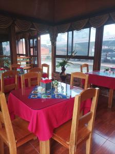 Nueva CaliforniaCabañas Mountain River Lake Inn的用餐室配有粉红色的桌子和椅子