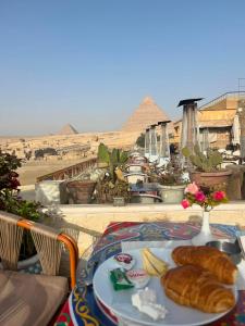 开罗Queen cleopatra sphinx view的底下有金字塔的桌子上的一盘食物