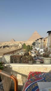 开罗Queen cleopatra sphinx view的阳台享有金字塔的景致,配有桌椅。