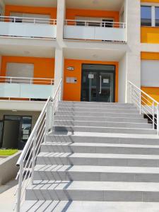 皮罗特Apartman Branković Pirot-Zapadni Kej 58的通往带橙色门的建筑的楼梯