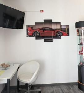 BrusimpianoIl Cavallino, sul lago Ceresio的一间房间,配有书桌和墙上的一辆红色汽车