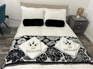 HookwoodAna guest house的一张带黑白棉被的床和毛巾