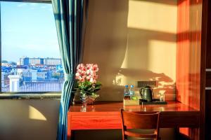 金边Notis International Hotel 诺蒂斯国际酒店的一张带花瓶和窗户的桌子