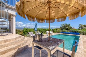 弗雷瑞斯Stunning Cote d'Azur Villa - Rives d'Or的游泳池旁带遮阳伞的桌子